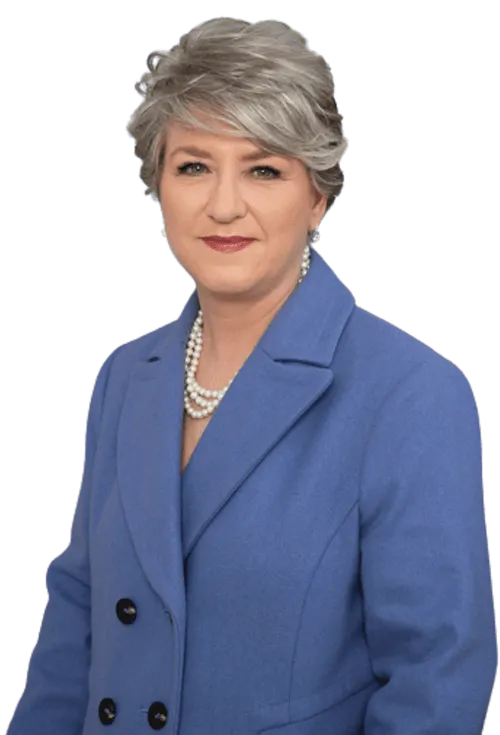 Smiling professional woman in a blue blazer and pearl necklace, presenting herself as a trusted Business Coach Newcastle.